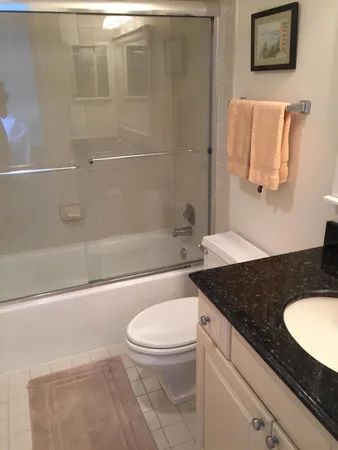 a bathroom with a granite countertop sink toilet and shower