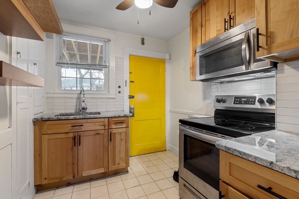 161 Florence Street, Unit 2 Boston, MA 02131 - Photo 6 of 13 a kitchen with stainless steel appliances granite countertop a sink stove and microwave
