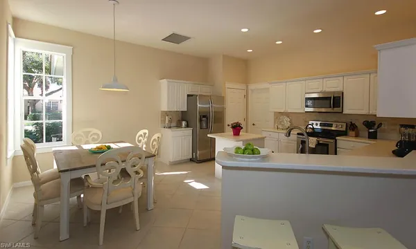 a kitchen with granite countertop a sink and chairs