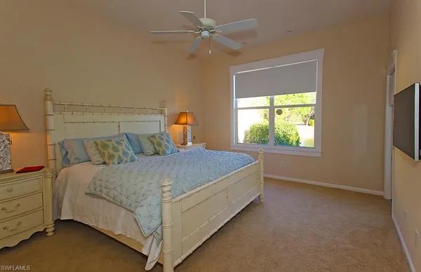 a bed sitting in a bedroom next to a window