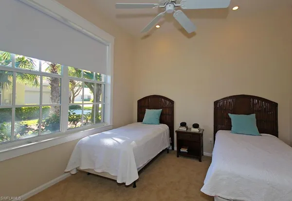 a bedroom with a bed and a large window