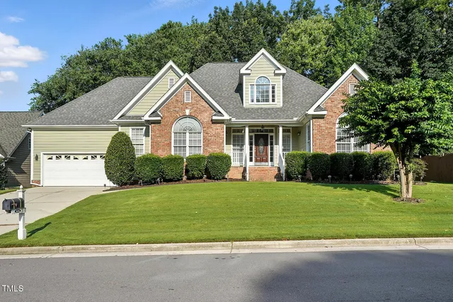a front view of a house with a yard and trees