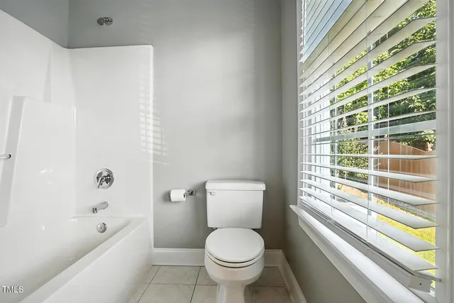 an empty room with a window and a ceiling fan