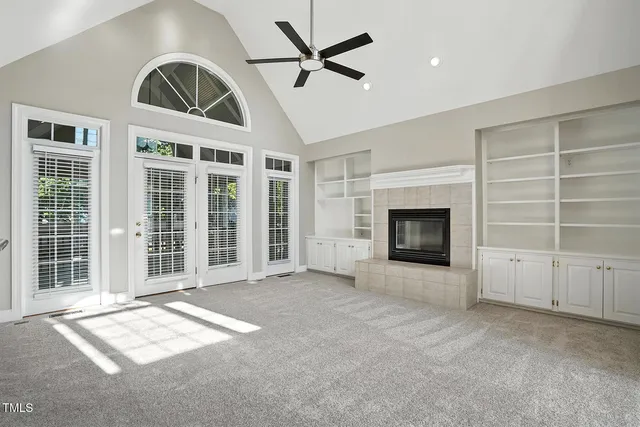 a view of an empty room with a fireplace and a window
