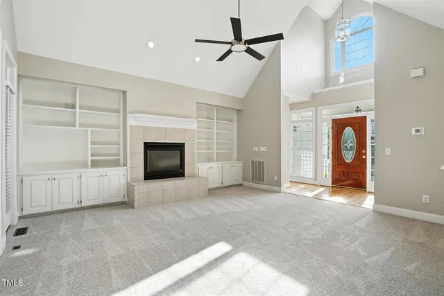 an empty room with windows and fireplace