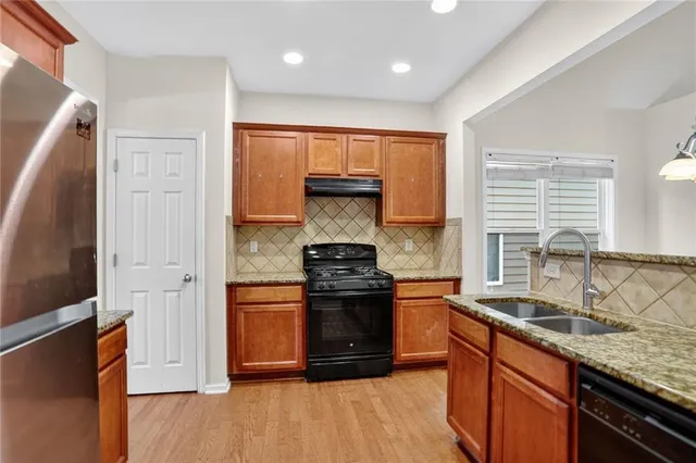 a kitchen with stainless steel appliances granite countertop a stove and a sink