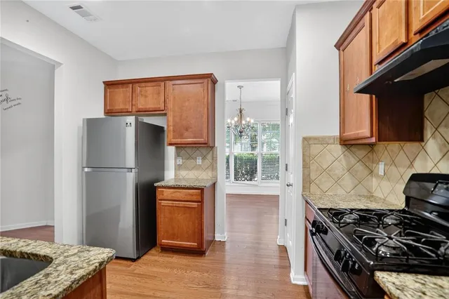 a kitchen with stainless steel appliances granite countertop a stove a refrigerator and a stove