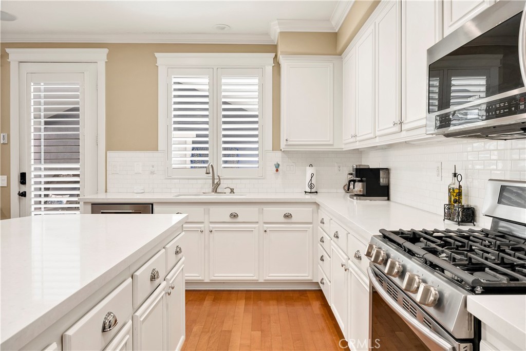 40152 Stowe Road Temecula, CA 92591 - Photo 20 of 56 a kitchen with granite countertop a stove a sink and a microwave