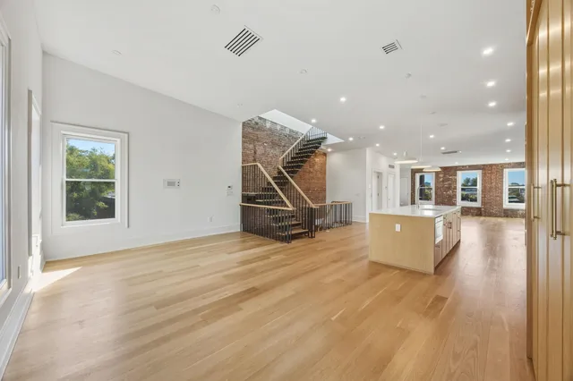 a view of a livingroom with furniture wooden floor and windows