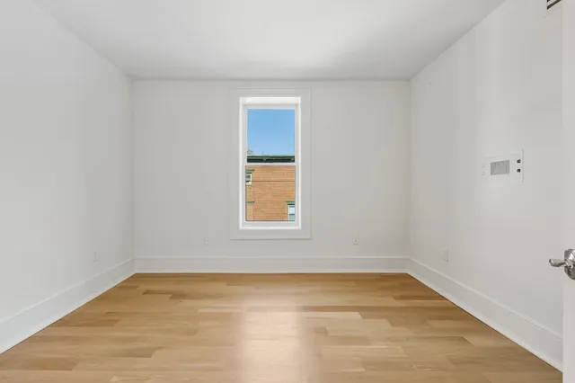 a view of empty room with wooden floor