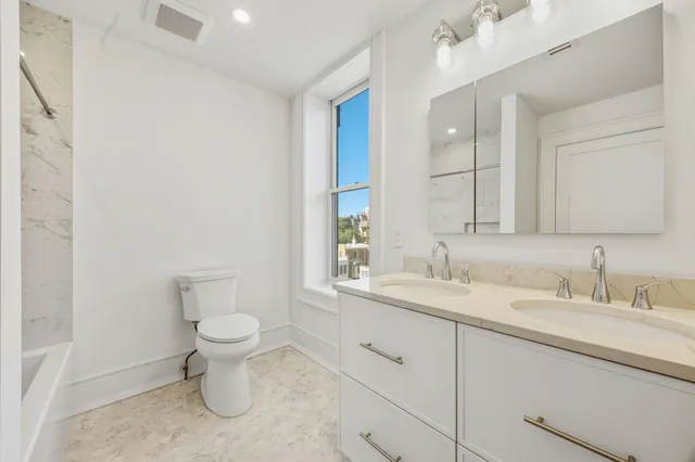 a bathroom with a sink toilet a mirror and vanity