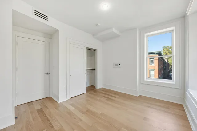 an empty room with windows and closet