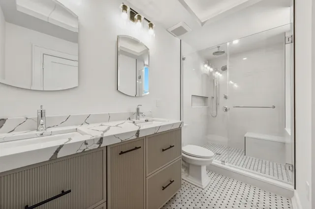 a bathroom with a sink a toilet and a mirror