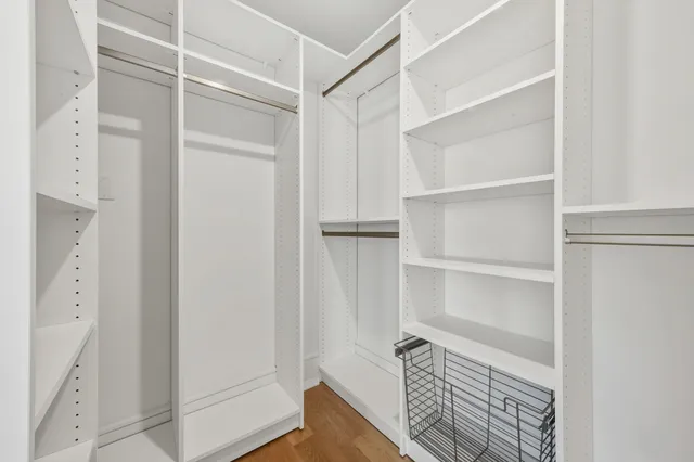 a view of walk in closet with empty racks
