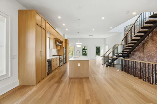 a view of a hallway with wooden floor windows and stairs
