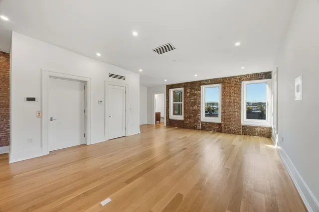 a view of a livingroom with wooden floor and window