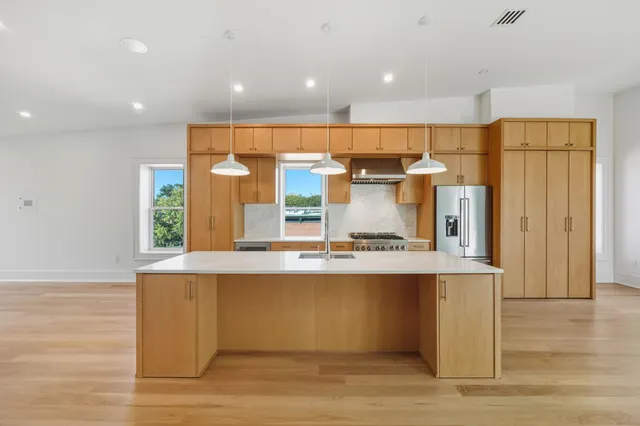 a view of kitchen with stainless steel appliances granite countertop a sink and a refrigerator