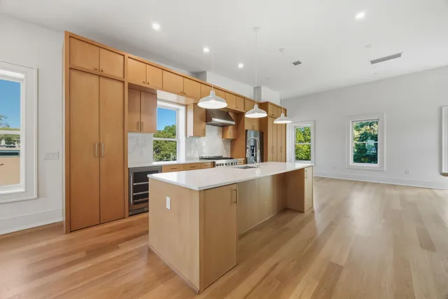 a large kitchen with stainless steel appliances granite countertop a sink and a large window