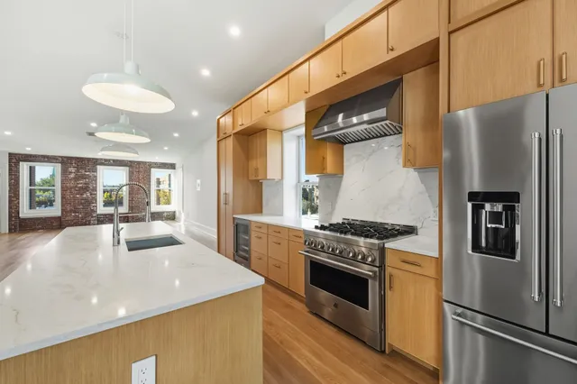 a kitchen with stainless steel appliances granite countertop a stove and a refrigerator