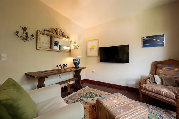 a living room with furniture a flat screen tv and a floor to ceiling window