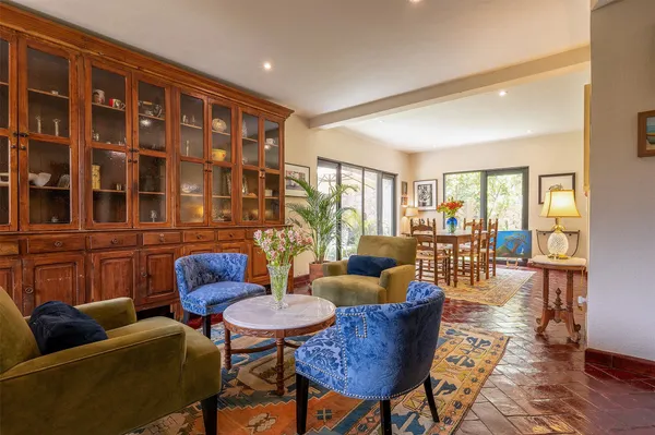 a living room with furniture wooden floor and a floor to ceiling window