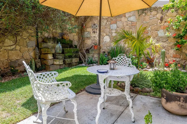 a view of a table and chairs in backyard of the house