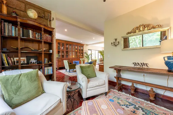 a living room with furniture a rug and a book shelf