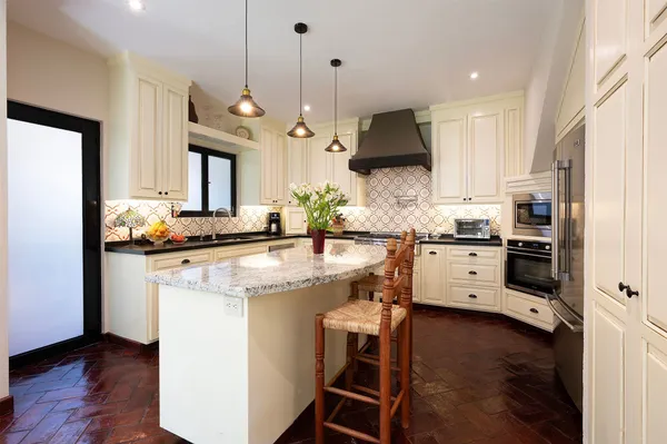 a kitchen with stainless steel appliances kitchen island granite countertop a stove a sink and a refrigerator