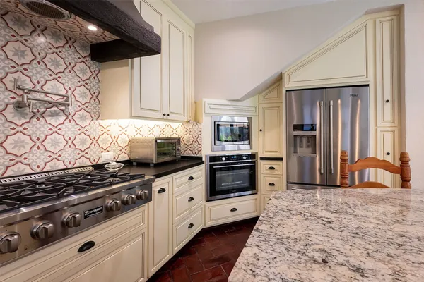a kitchen with stainless steel appliances a stove a sink and a refrigerator