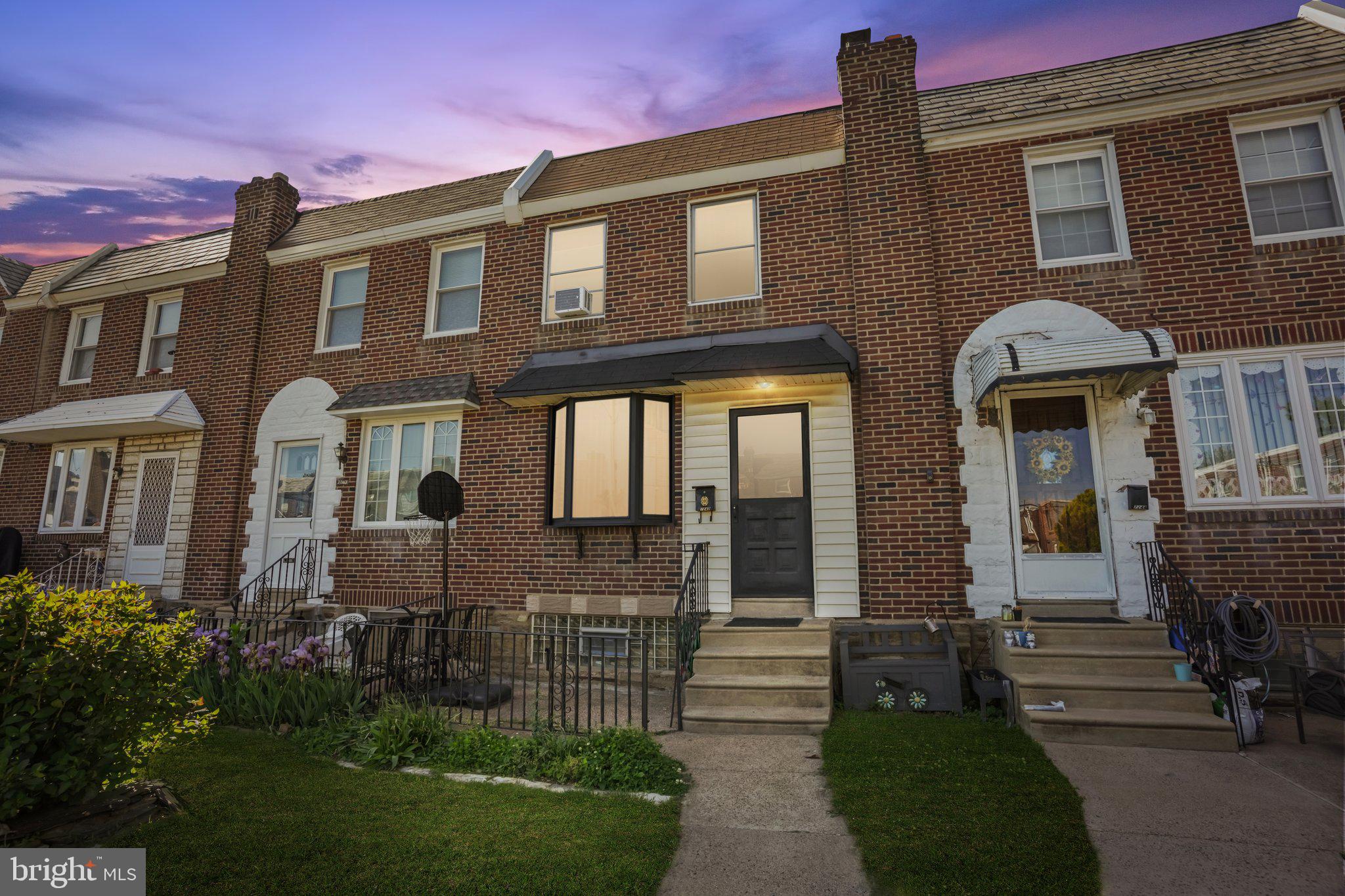 7242 Algard Street Philadelphia, PA 19135 - Photo 1 of 25 Charming brick townhouse at dusk.