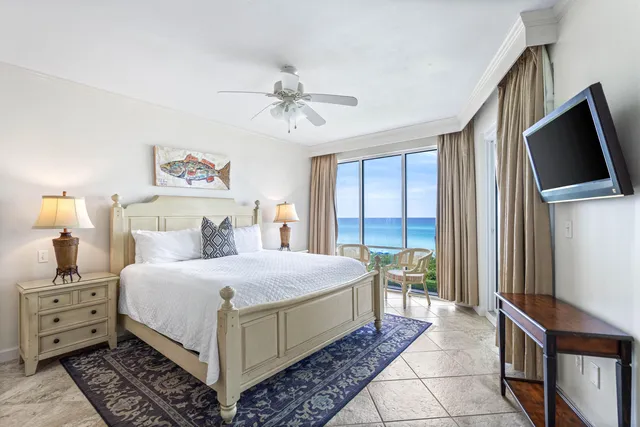 a bedroom with a large bed and a flat tv screen on dresser