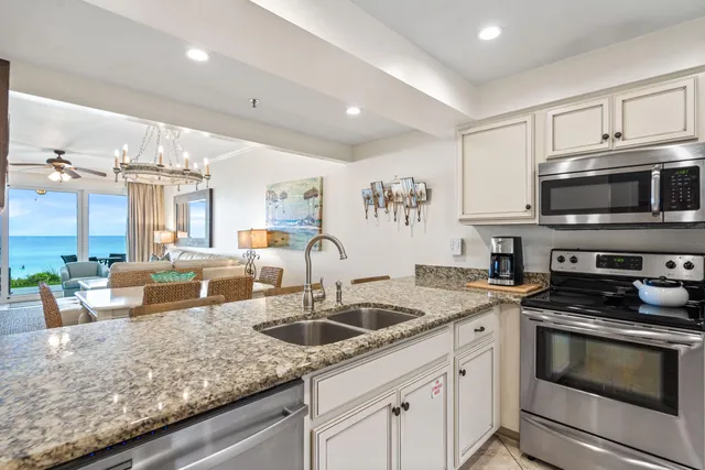 a kitchen with granite countertop a sink a stove and cabinets