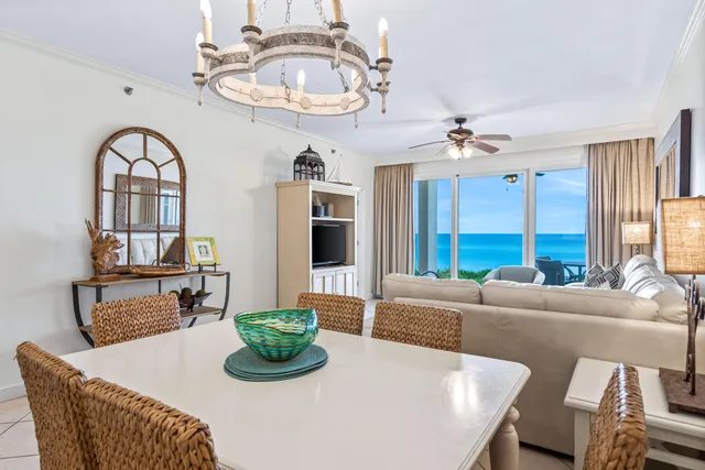 a living room with furniture a chandelier and a large window