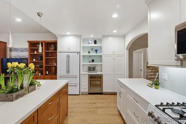 a kitchen with stainless steel appliances kitchen island granite countertop a sink a stove and a refrigerator