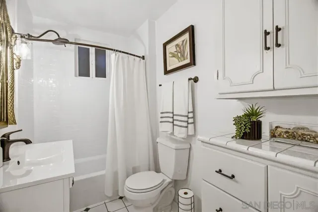 a bathroom with a granite countertop sink toilet and mirror