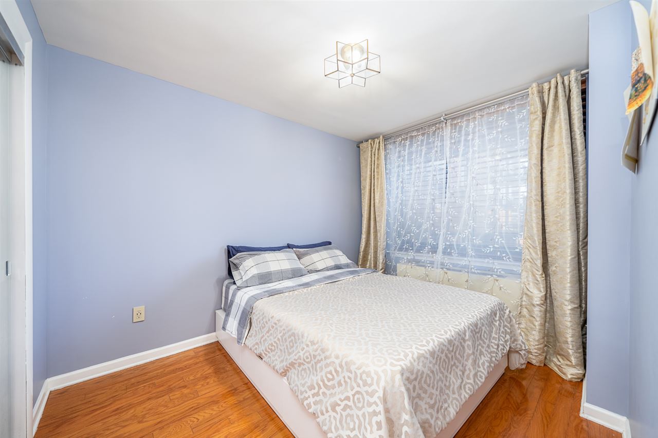 700 Grove Street, Unit 4V Jersey City, NJ 07310 - Photo 12 of 25 a bedroom with a bed and a chandelier