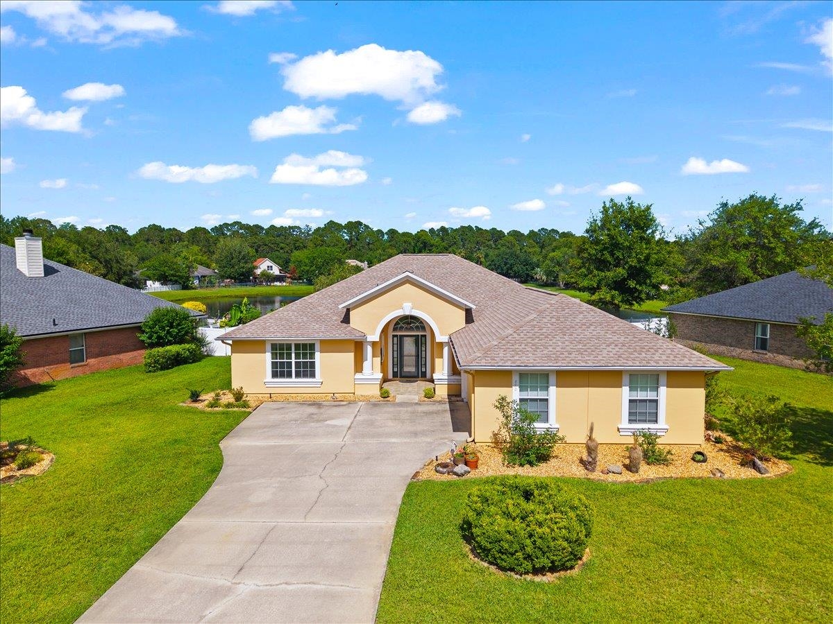 880 East Red House Branch Road St. Augustine, FL 32084 - Photo 1 of 65 a front view of a house with a yard