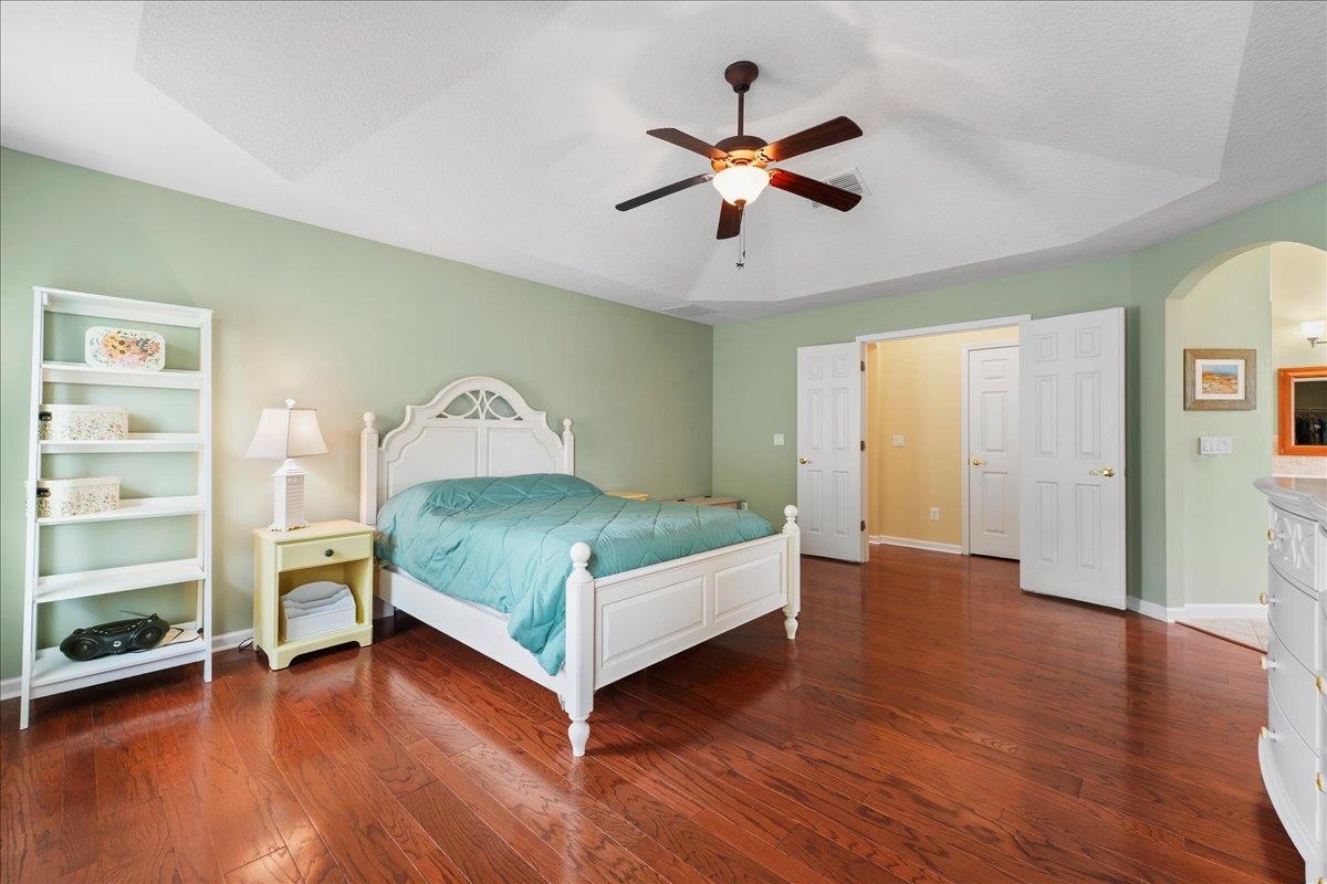 880 East Red House Branch Road St. Augustine, FL 32084 - Photo 18 of 65 a bedroom with a large bed and a chandelier