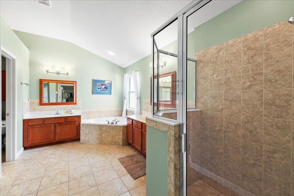 880 East Red House Branch Road St. Augustine, FL 32084 - Photo 19 of 65 a large bathroom with a granite countertop tub sink shower and mirror
