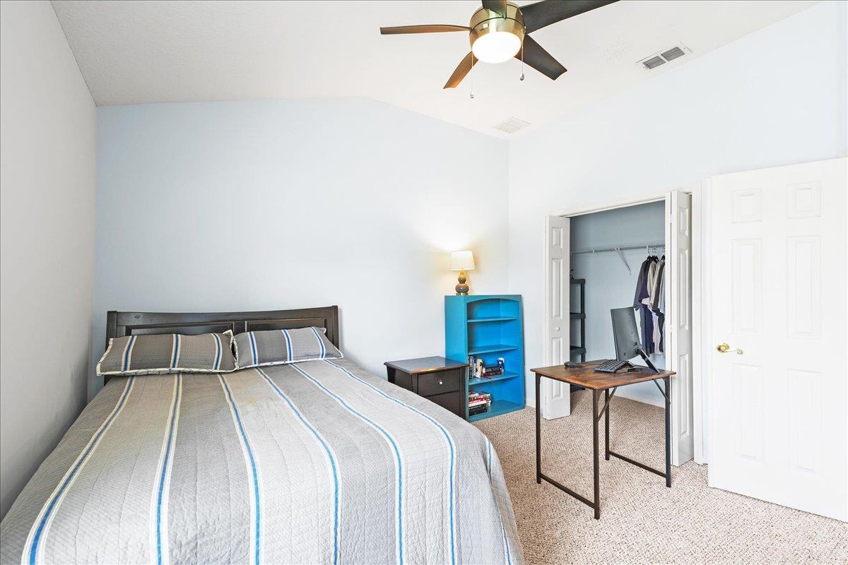 880 East Red House Branch Road St. Augustine, FL 32084 - Photo 28 of 65 a bedroom with a bed and a chandelier