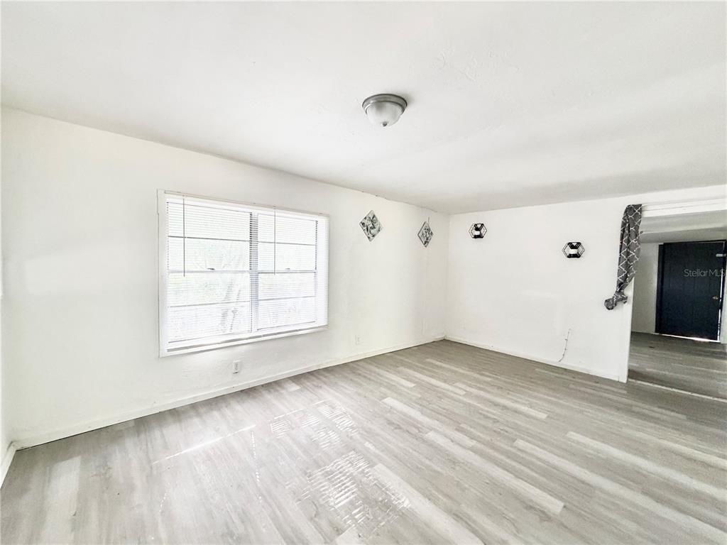 21433 Southeast Hawthorne Road Hawthorne, FL 32640 - Photo 5 of 19 an empty room with wooden floor and windows
