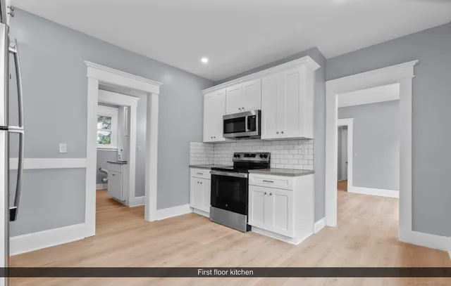 a kitchen with a refrigerator stove and white cabinets
