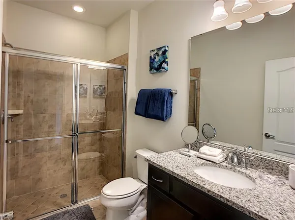 a bathroom with a granite countertop sink toilet and shower
