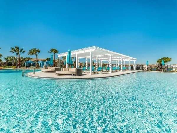 a front view of a house with swimming pool and chairs