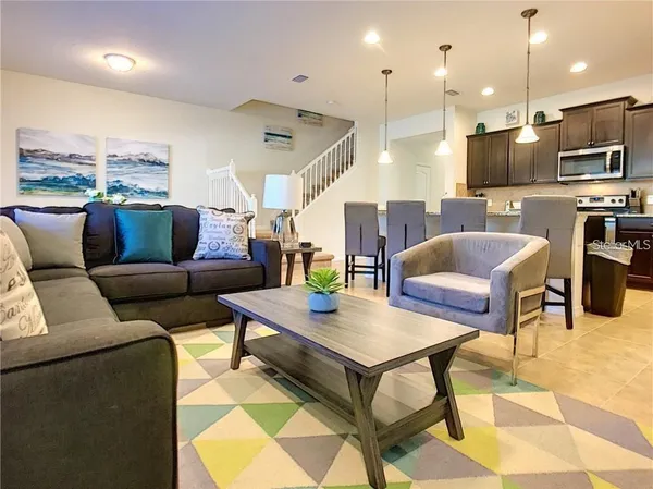 a living room with furniture and kitchen view