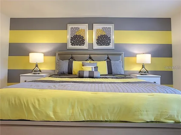 a bed sitting in a bedroom next to a window with lamp