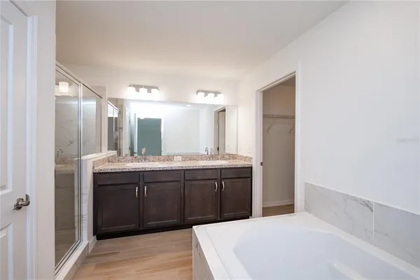 a spacious bathroom with a granite countertop sink and mirror