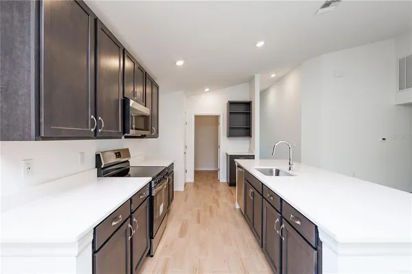 a kitchen with stainless steel appliances a sink stove and cabinets