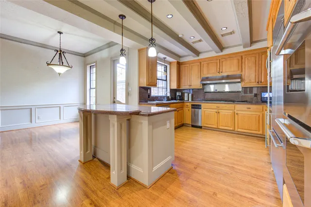 a kitchen with stainless steel appliances granite countertop a stove a sink and a refrigerator