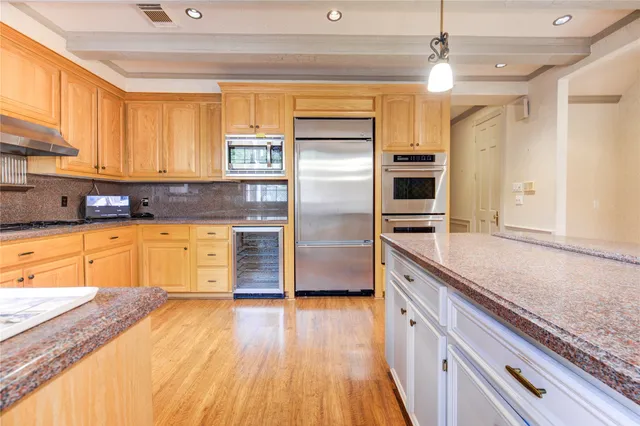 a kitchen with stainless steel appliances granite countertop a refrigerator a sink and a stove